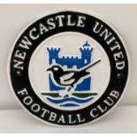 A circular shaped cast iron Newcastle United FC wall hanging plaque.