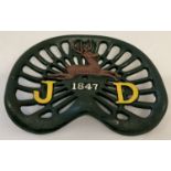 A painted cast metal tractor seat with John Deere logo.