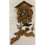 A vintage German Black Forest style wooden cased cuckoo clock, complete with pendulum and weights.