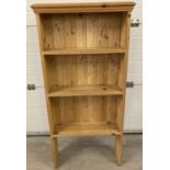 A modern pine 3 shelf bookcase with shaped plinth top.