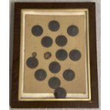 A framed and glazed collection of 13 miniature Wedgwood black basalt round portrait plaques.