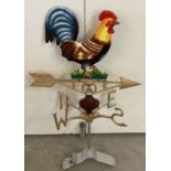 A modern painted cast metal weather vane with cockerel detail.