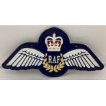A painted cast iron RAF wings wall plaque with fixing holes.