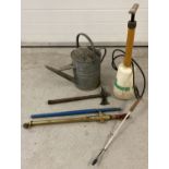 A small collection of gardening tools to include a brass sprayer, galvanised watering can & an axe.