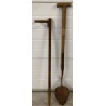 A vintage long wooden handled peat cutter together with a vintage metal fence support ring.