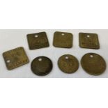 A collection of 7 brass miners pit check tokens.