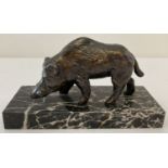 A small bronze boar figure on a black and white marble base.