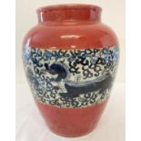 A large Chinese bulbous vase with red coloured glaze and blue and white handpainted panel detail.