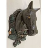 A large painted cast metal, wall mountable horse head with ring.