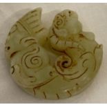A Chinese Jade carved roundel depicting figural detail to one end & mythical creature to the other.