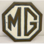 A painted cast iron, octagonal shaped MG wall plaque with fixing holes.