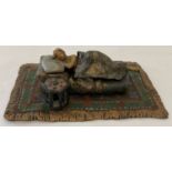 After Bergmann - a cold painted figurine of a sleeping woman on a floral carpet. Marks to base.