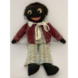 An early 20th century hand made Golly toy with original clothing and real fur hair.