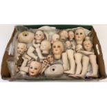 A box of assorted ceramic dolls heads and body parts.