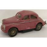 A vintage Victory Industries 1954 red/pink plastic battery operated Morris Minor toy car.