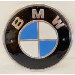 A painted aluminium circular shaped BMW wall hanging plaque.