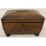 An antique wooden sarcophagus shaped tea caddy complete with key.