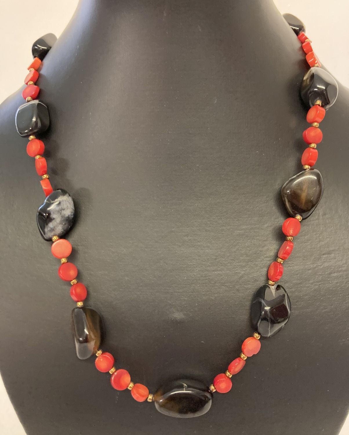 A 19" costume jewellery necklace made from disc shaped coral beads and polished onyx beads.