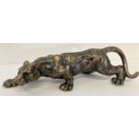 A heavy bronzed effect cast metal figurine of a stalking panther