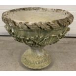 A large carved stone pedestal round planter with scallop shell and floral decoration.