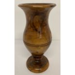 A carved wooden wide rimmed vase on shaped stemmed base.