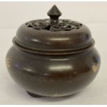 A Chinese bronze lidded censer with gold splash detail and pierced work lid.