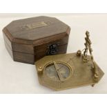 A brass sundial compass, marked "Gilbert & Sons", in a dark wood box.