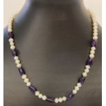 A freshwater pearl and amethyst beaded necklace with silver tone magnetic clasp.
