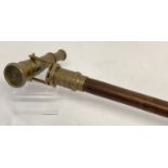 A reproduction wood and brass walking stick with swivel top telescope/compass handle.