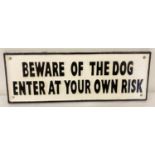 A black and white painted cast metal "Beware of the Dog" wall plaque.