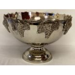 A large silver plated punch bowl with bunches of grapes detailed to rim of outer bowl.