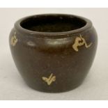 A miniature Chinese bronze censer with gold splash detail.