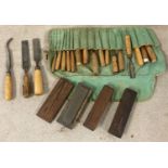 A collection of 16 vintage varying sized chisels in a cloth roll.