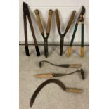 A small collection of mostly wooden handled gardening tools.