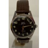 A vintage HMT Jawan military issue wristwatch on replacement leather strap.