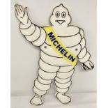 A painted cast metal wall hanging advertising plaque in the shape of the Michelin Man.
