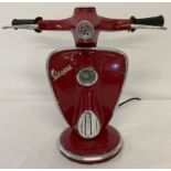 A novelty table lamp in the shape of the handlebars of a Vespa scooter, painted red.