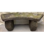 A large vintage painted brown concrete garden bench with log design to seat and supports.