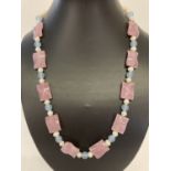 A 22" fresh water pearl necklace with pink and blue jade beads and gold tone hook clasp.