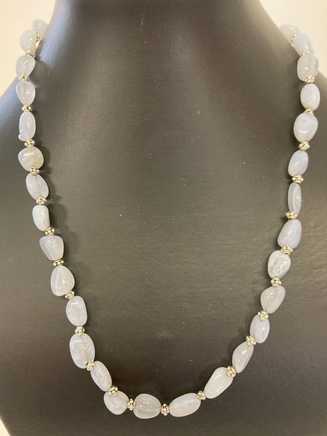 A 20" blue chalcedony and white metal beaded necklace with decorative silver tone T bar clasp.