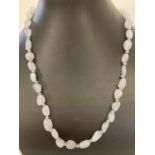A 20" blue chalcedony and white metal beaded necklace with decorative silver tone T bar clasp.