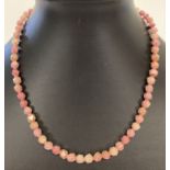 A faceted rhodonite beaded necklace with silver T bar clasp, approx. 16" long.