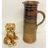 2 pieces of Studio pottery. A tall brown, partly glazed jug together with a Yare Designs Lion.
