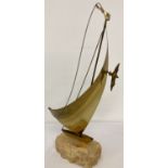A mid 20th century brass sail boat sculpture by John & Don DeMott with flag and seagull detail.