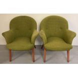 A pair of mid century upholstered armchairs with wooden splayed feet, metal frames and sprung seats.