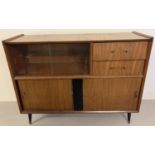 A 1960's teak sideboard with sliding door cupboards, drawers and glass panels.