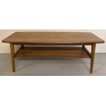 A vintage mid century solid wood coffee table with slatted undershelf and tubular legs.