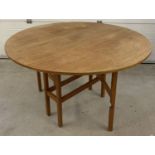 A vintage 1970's teak circular drop leaf, gate leg table.