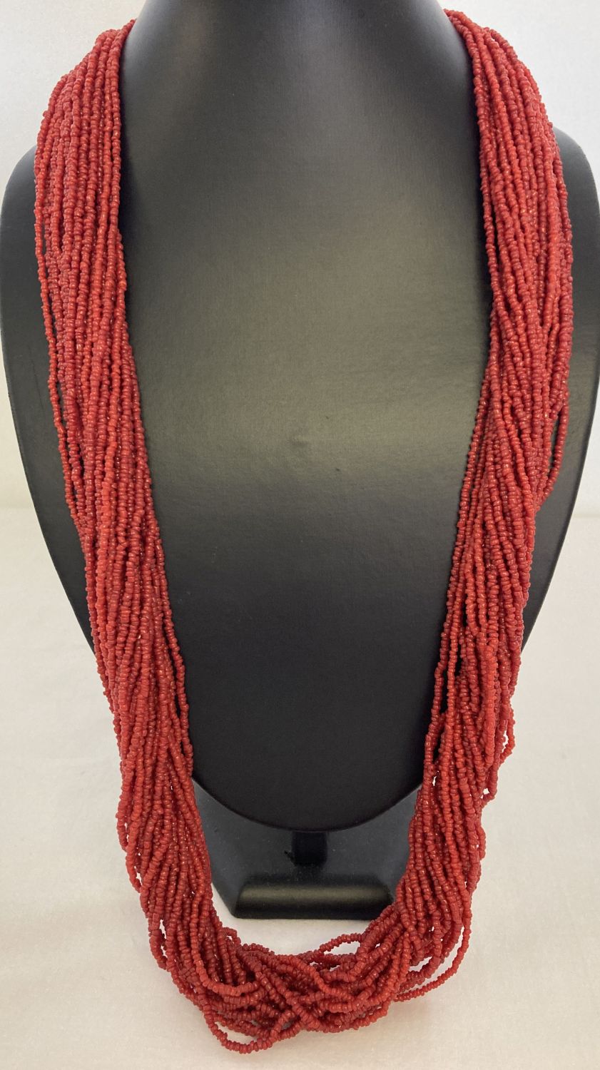 A multi strand coral chip necklace with silver tone hook and eye claps.