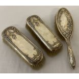 A pair of antique silver backed clothes brushes with floral and flower basket decoration.